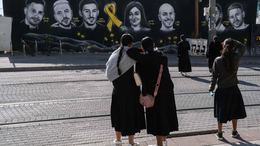 Porträts von sieben verschleppten Geiseln sind auf einer Wand in Jerusalem zu sehen.