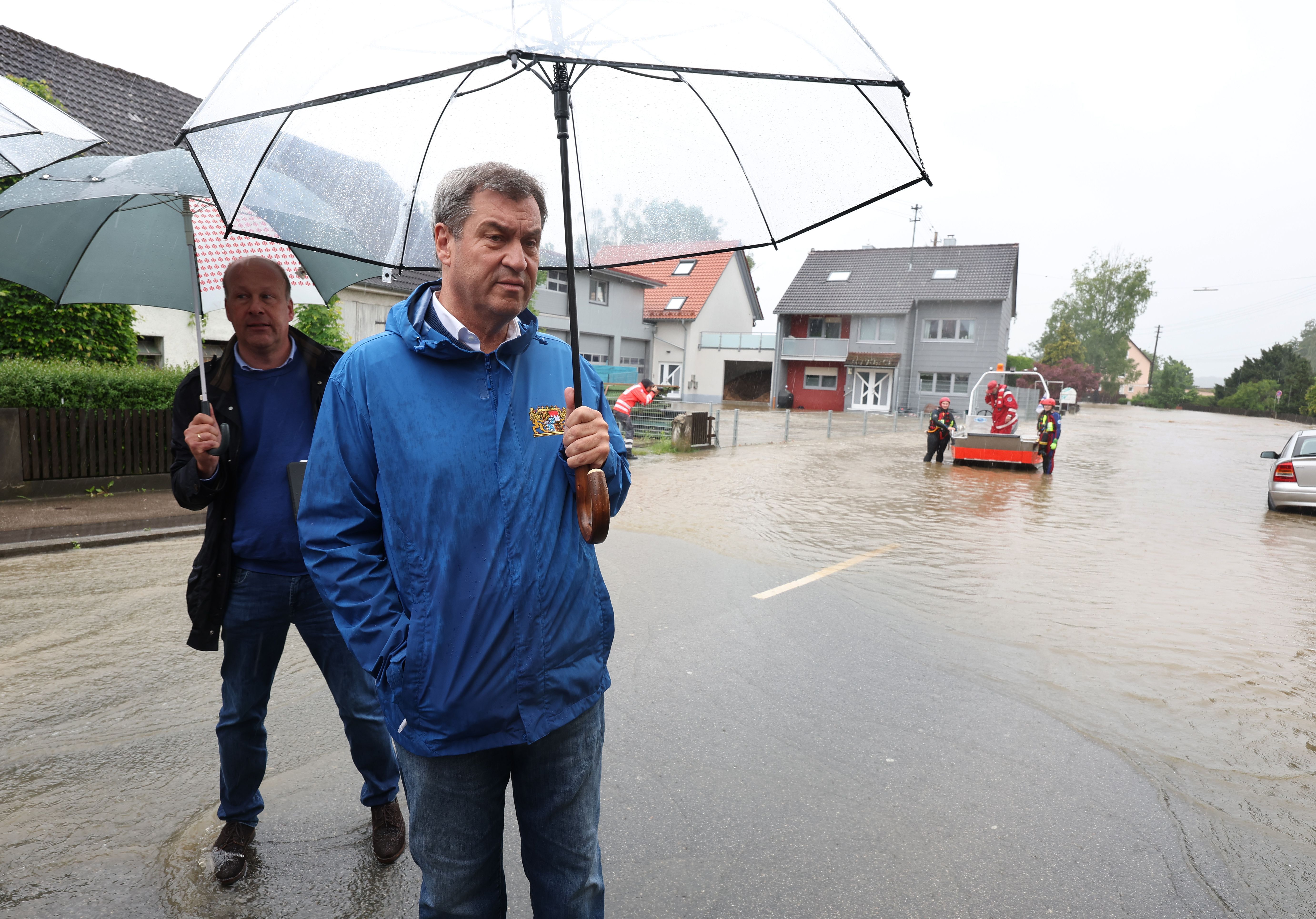 Bayern, Diedorf: Markus Söder (CSU), bayerischer Ministerpräsident, steht auf einer überfluteten Straße.