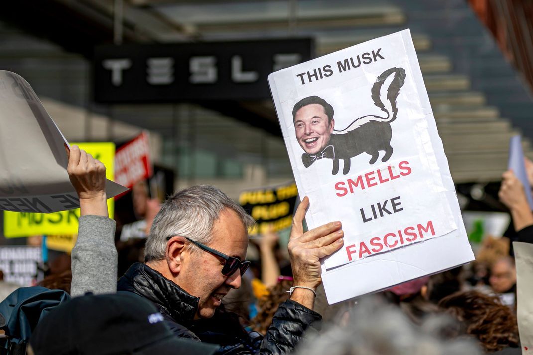 Ein Demonstrant übt Kritik gegenüber Elon Musk,