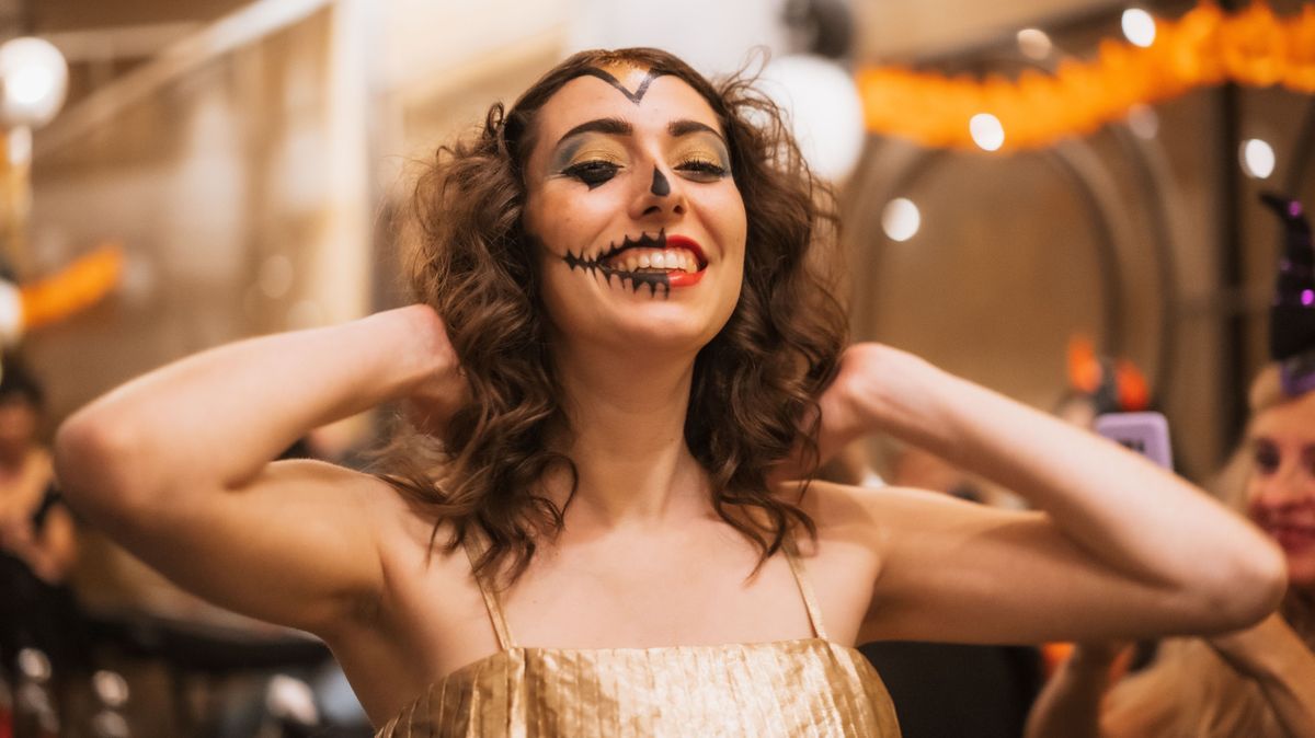 Portrait of a woman singing in costume and makeup at the halloween party in a disco nightclub