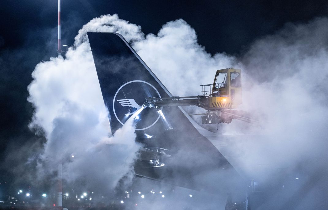 Am Flughafen Frankfurt am Main wird eine Lufthansa-Maschine enteist. Angesichts der Wetterlage hat der Flughafen den Flugplan zusammengestrichen. 