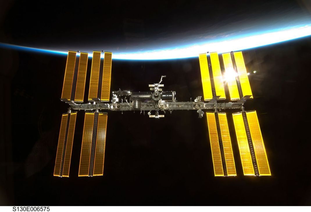 Die großen Sonnenpaneelen der ISS reflektieren das Sonnenlicht wie ein Spiegel zur Erde. 