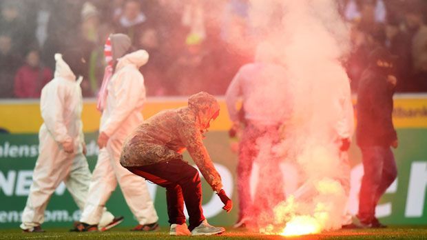 
                <strong>Hochsicherheits-Derby zwischen Gladbach und Köln</strong><br>
                Damals waren hunderte Kölner mit Maleranzügen samt Kapuzen und Masken ins Stadion gelangt und hatten das Spielfeld gestürmt und Pyro auf den Rasen geworfen.
              