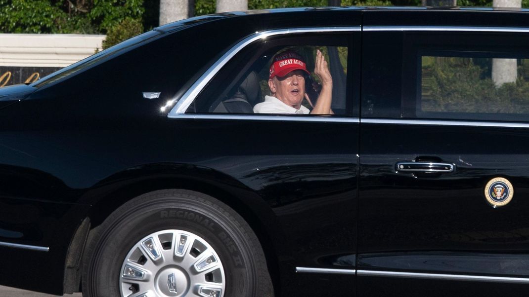 8. März 2025, USA, West Palm Beach: US-Präsident Donald Trump winkt aus seiner Limousine, als er in seinem Golfclub in West Palm Beach ankommt. 