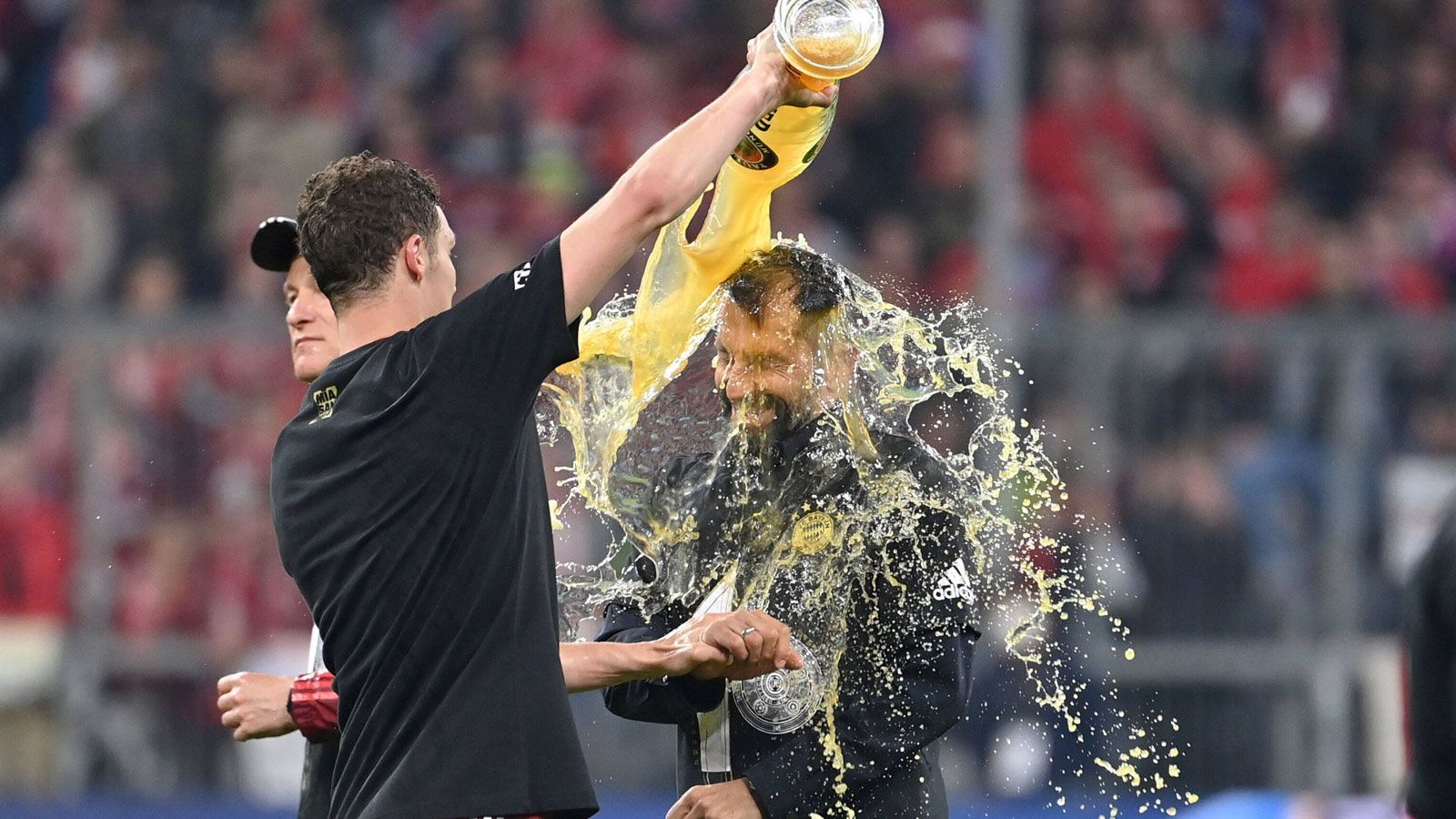 
                <strong>Pavard duscht Salihamidzic</strong><br>
                Unter diesem Schwall Gerstensaft versteckt sich ein bekannter Sportvorstand. Ob Benjamin Pavard bei den nächsten Vertragsverhandlungen nun ein paar zusätzliche Argumente vorlegen muss, ist nicht überliefert.
              