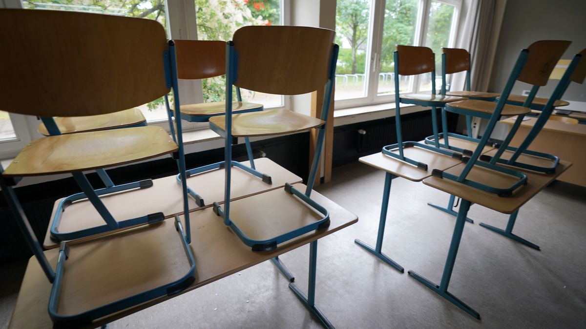 Stühle stehen in einem Klassenraum in einer Schule auf den Tischen.