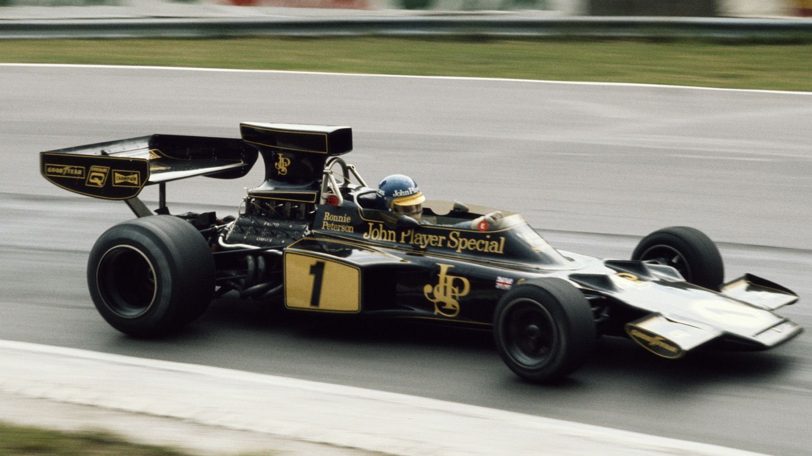 
                <strong>Lotus Ford 72E (1974) </strong><br>
                Etwas schlanker in der Optik kamen die Front- und Heckspoiler der Rennwagen ab Mitte der 1970er Jahre zur Geltung. Wie hier bei Ronnie Peterson im Lotus Ford 72E beim Großen Preis von Großbritannien im Jahr 1974 auf dem legendären Brands Hatch Kurs in Fawkham. Übergroße Lufteinlässe über dem Fahrercockpit prägten die Optik der Boliden Mitte der 70er.  
              