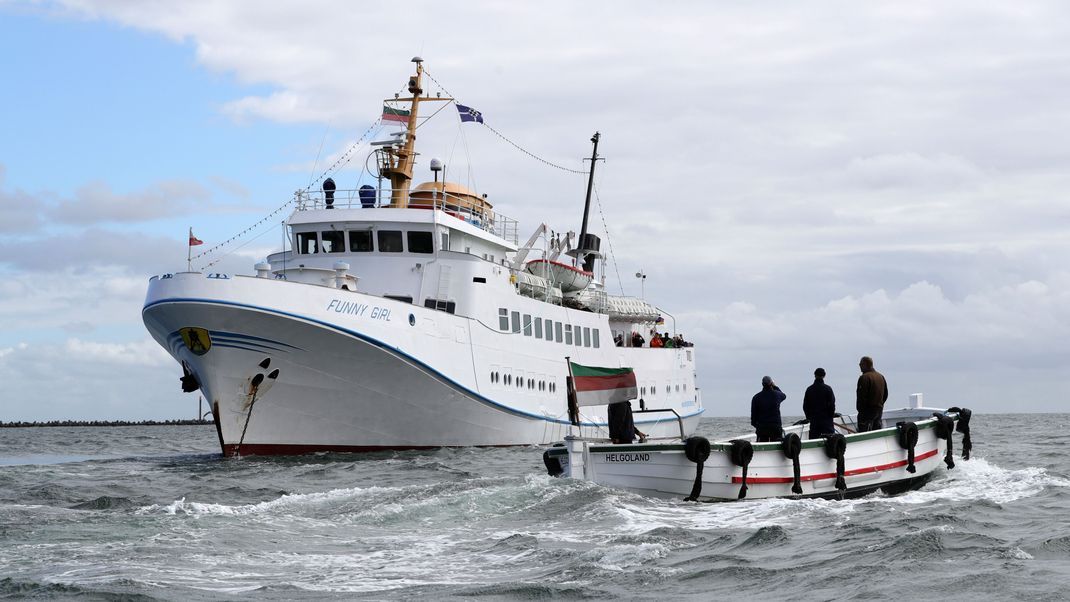 Ein Börteboot ist  auf dem Weg zu dem Ausflugsschiff "Funny Girl".