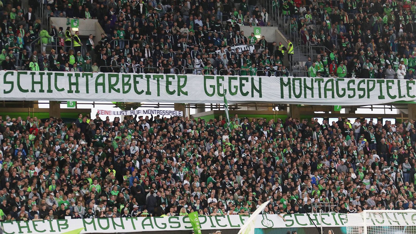 
                <strong>VfL-Anhänger denken an eigene Arbeit</strong><br>
                Ebenso zeigen die Zuschauer der Heimmannschaft ihren Unmut. "Schichtarbeiter gegen Montagsspiele", zeigt ein Banner in der Heimkurve. Die VfL-Fans nehmen sich dabei selbst aufs Korn. Schließlich werden ja alle Anhänger der Wölfe als Fließbandarbeiter beim ortsansässigen Autowerk verallgemeinert.
              