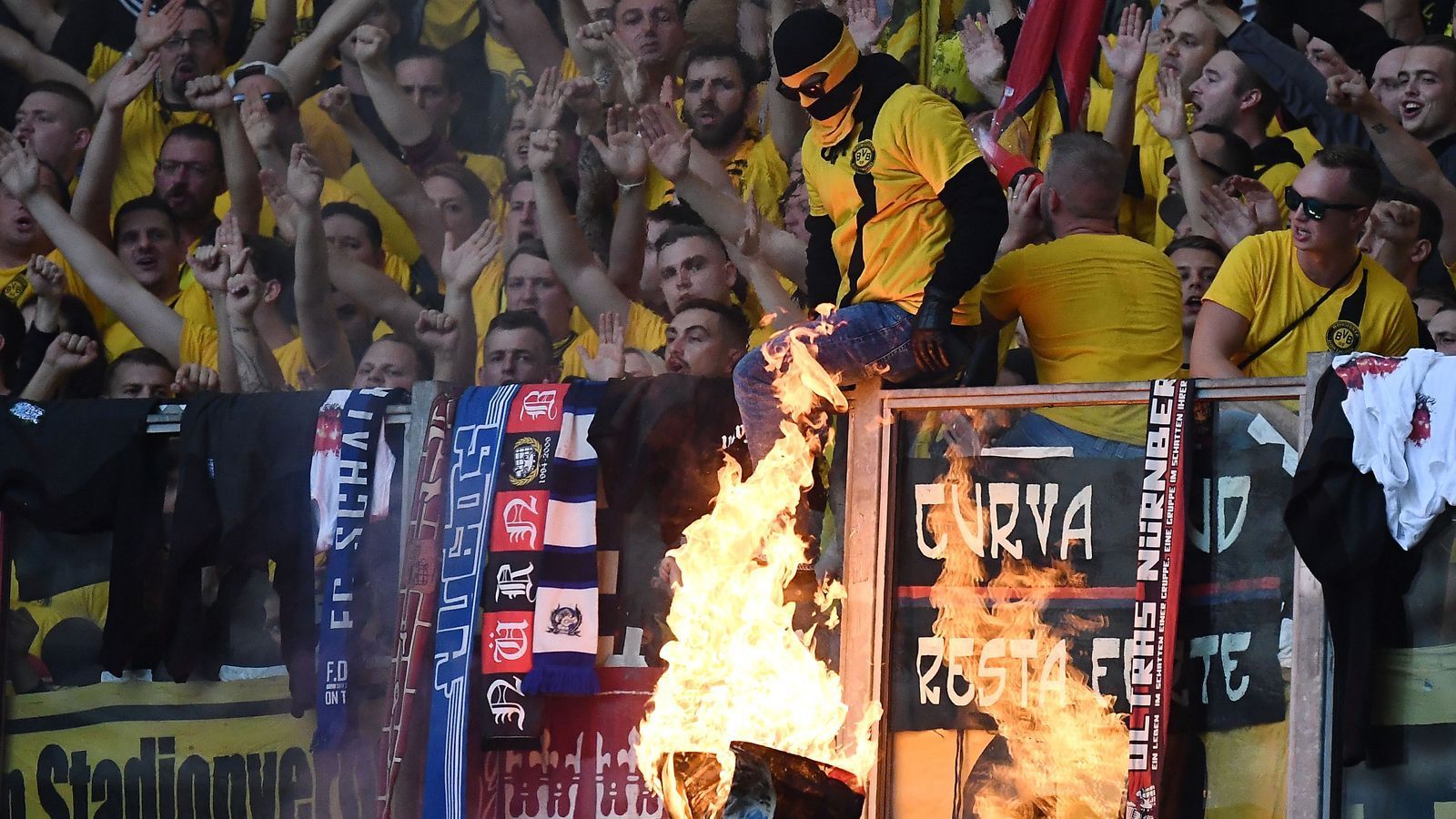 
                <strong>Bundesliga: Impressionen vom Revierderby 2019/20</strong><br>
                Feuer war schon vor dem Anstoß im Revierderby drin. Nicht zuletzt, weil die BVB-Ultras damit provozierten, eine Schalke-Fahne im Fanblock abzufackeln. 
              