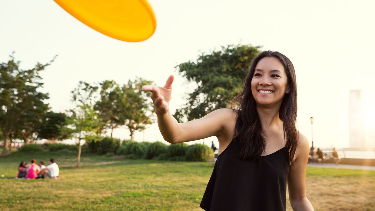 Young woman throwing plastic disc