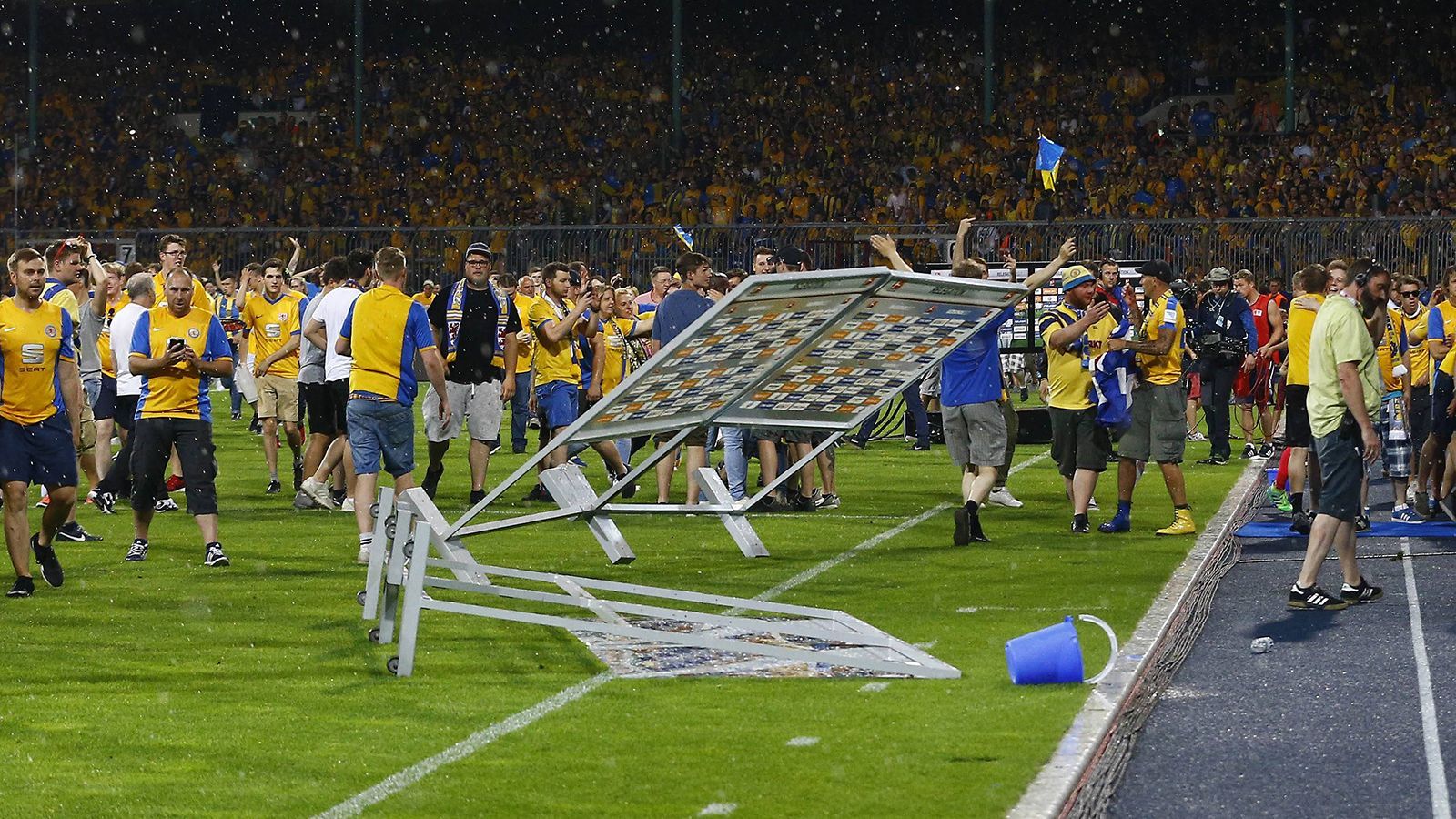 <strong>Braunschweiger Fans stürmen Platz</strong><br>Böller wurden geworfen, eine Rakete landete in einer Polizistengruppe. Die Situation konnte letztendlich aber unter Kontrolle gebracht werden. Als "unglaubliche Sauerei" bezeichnete Braunschweig-Präsident Sebastian Ebel später das Verhalten der Fans. Wolfsburg kam nach dem Trubel noch einmal aus der Kabine und konnten den Klassenverbleib doch noch ein wenig zelebrieren.