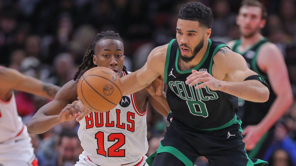 CHICAGO, IL - MARCH 23: Ayo Dosunmu 12 of the Chicago Bulls pushes the ball away from Jayson Tatum 0 of the Boston Celtics during the second half at the United Center on March 23, 2024 in Chicago, ...