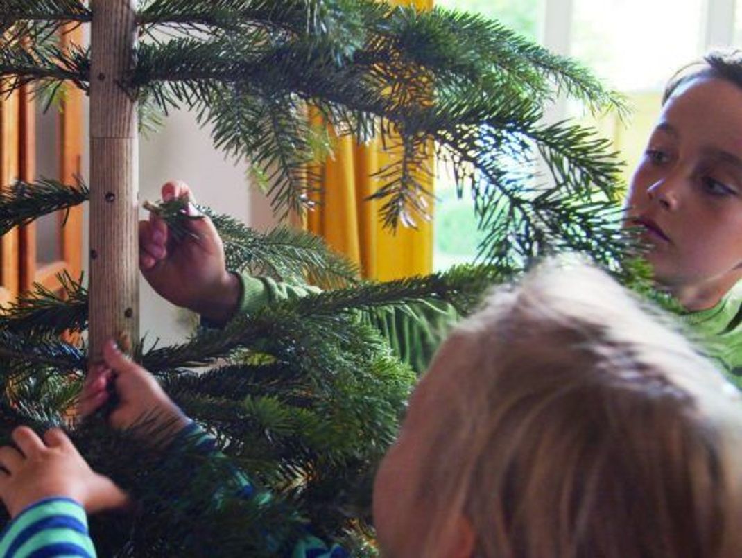 Fast wie ein echter! Der Baum besteht aus einem Holzständer, in den man beim Schmücken Tannengrün steckt.