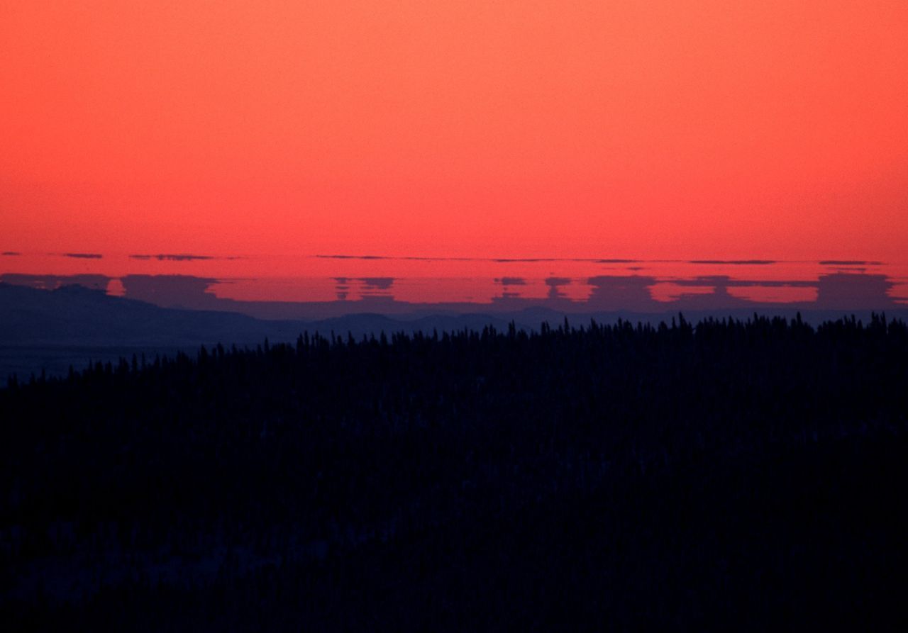 Im roten Licht der Abendsonne spiegelt sich die Landschaft in Kanada am Polarkreis.