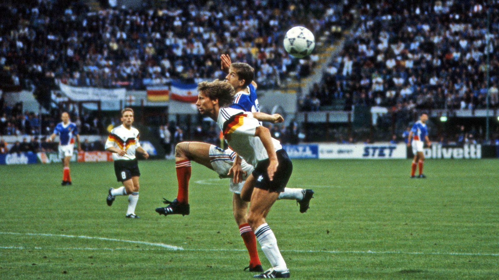 
                <strong>WM 1990: Deutschland - Jugoslawien</strong><br>
                Trotz der Auftaktniederlage kam Jugoslawien noch bis ins Viertelfinale und scheiterte dort erst im Elfmeterschießen am späteren Vizeweltmeister Argentinien. Hier liefern sich zwei Spieler einen Zweikampf, die einst zusammen beim VfB Stuttgart spielten: Srecko Katanec und Guido Buchwald.
              