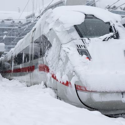 Ein ICE der Deutschen Bahn (DB) steht auf einem verschneiten Gleis am Münchner Hauptbahnhof. 