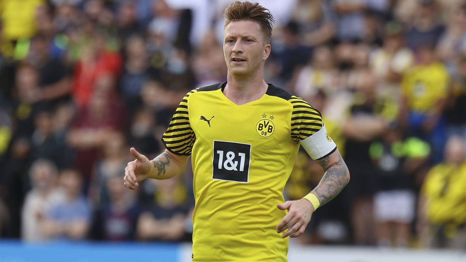 
                <strong>Die Kapitänsfrage</strong><br>
                Marco Reus geht nun in seine vierte Saison als etatmäßiger Kapitän von Borussia Dortmund. Während es intern wenig Zweifel an dem 32-Jährigen gibt, wird dieses Amt von Medien und Experten in regelmäßigen Abständen angezweifelt. Meist genanntes Argument ist die Verletzungsanfälligkeit von Reus, aber wenn der Nationalspieler auf dem Platz steht, dann verhält er sich auch zumeist wie ein Kapitän, gibt Anweisungen und steht stets zum Interview nach dem Spiel bereit. Während, wie erwähnt, intern bei dieser Personalie alles klar ist, wird es darauf ankommen, das gegenüber der Presse wegzumoderieren.
              