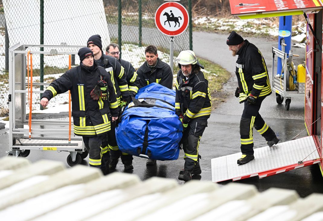Nordrhein-Westfalen, Freudenberg: Feuerwehrleute entladen ihre Ausrüstung für den Einsatz nahe des Fundorts von Luises Leiche. 