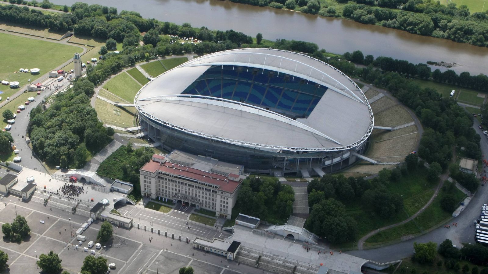 
                <strong>Platz 13: Red Bull Arena (RB Leipzig)</strong><br>
                Ähnliche Stimmen wie beim Berliner Olympiastadion monieren auch bei der Leipziger Red Bull Arena das Fehlen von Stehplätzen. Dafür war das ehemalige Zentralstadion damals nicht ausgerichtet, gab es doch lange Zeit keinen Klub, der dieses hätte füllen können. Immerhin: Das Stadion liegt am Wasser, was für Viele ein großer Pluspunkt ist, und im Süden der Arena ist eine große Festwiese. Diese lädt an warmen Spieltagen zum Zusammenkommen oder gar selbst zum Kicken ein. Da ist dann auch bessere Stimmung.
              