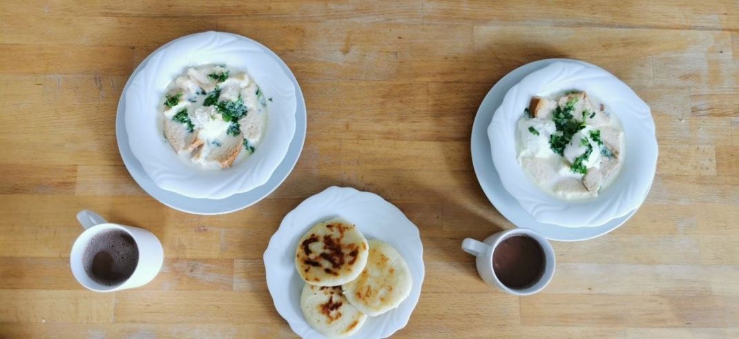 So sieht Frühstück auf kolumbianisch aus. Es gibt Changua, eine herzhafte Frühstückssuppe, und Chocolate Santafereño, eine Art heiße Schokolade. 