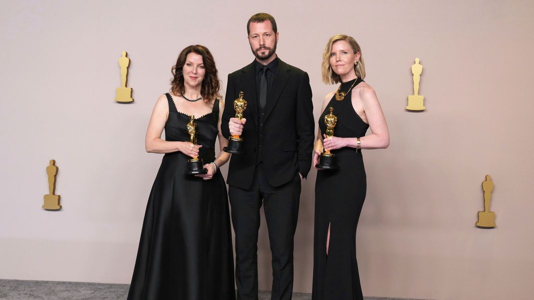 Raney Aronson-Rath, Mstyslav Chernoc und Michelle Mizner mit ihren Oscars für "20 Tage Mariupol".