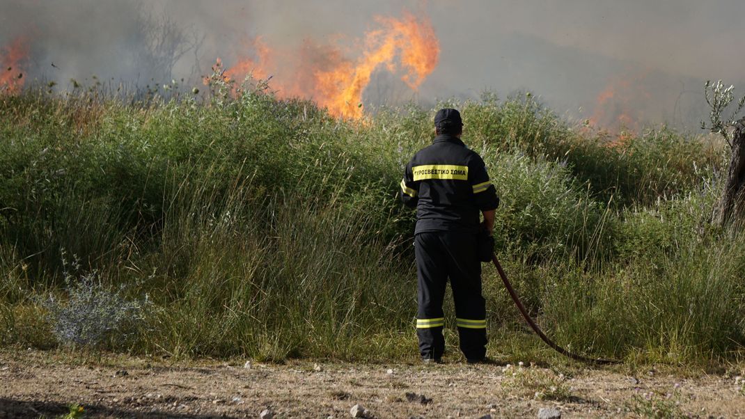 2017. LESBOS, GREECE. The firebrigade in Lesbos is trying to extinguish a fire with the help of volunteers and airplanes.