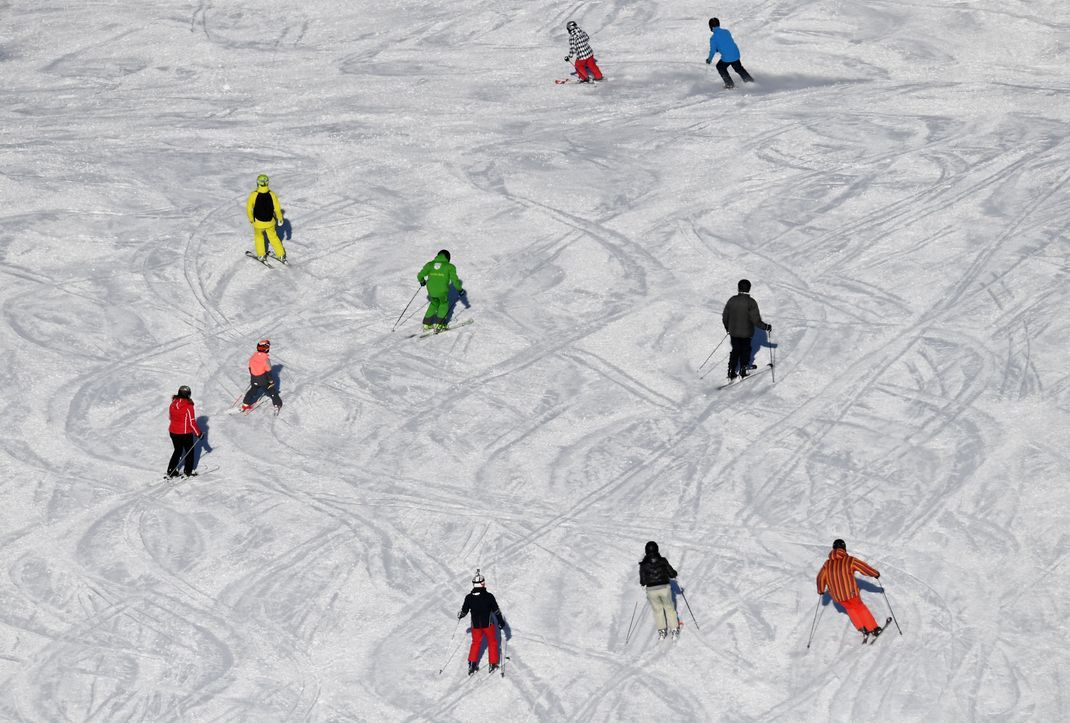Skifahrer fahren bei Sonnenschein auf einer Skipiste. Ungeachtet steigender Temperaturen und abnehmender Schneemengen droht den alpinen Winterurlaubsorten in den nächsten Jahren kein vorzeitiges Ende ihrer Geschäfte. 