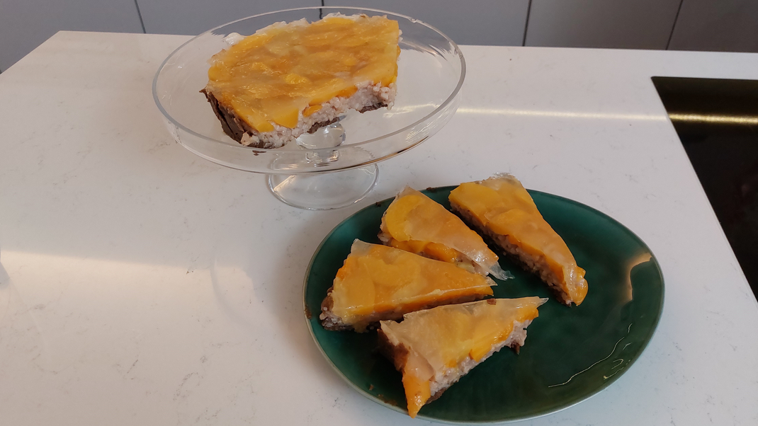 Pumpernickel-Dattel-Boden mit Milchreisfüllung und Pfirsich-Ananas-Mandarin Topping&nbsp;