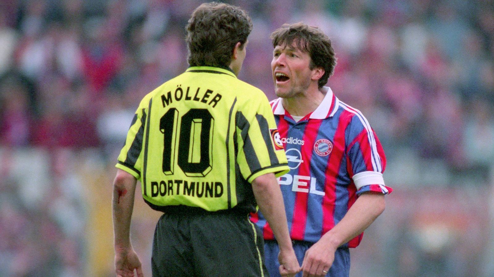 <strong>Bundesliga 1996/97</strong><br>
                Auf der Trainerbank heißt das Duell noch Giovanni Trapattoni gegen&nbsp;Ottmar Hitzfeld. Auf dem Spielfeld Andreas Möller gegen Lothar Matthäus. Als Möller nach einem Foul von Mario Basler übertrieben abhebt, knöpft sich Matthäus den Dortmunder vor und geigt seinem Nationalmannschaftskollegen die Meinung.