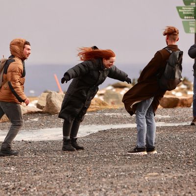 Besucher auf dem Brocken kämpfen gegen den Sturm an.