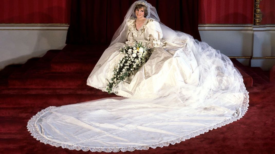 Gleich zwei Designer:Innen kreierten diesen Traum in Weiß aus Seide für die Hochzeit mit Prinz Charles am 29. Juli 1981.