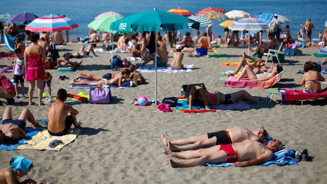 Badegäste auf Handtüchern - soll es bald an vielen Stränden in Italien nicht mehr erlaubt sein.