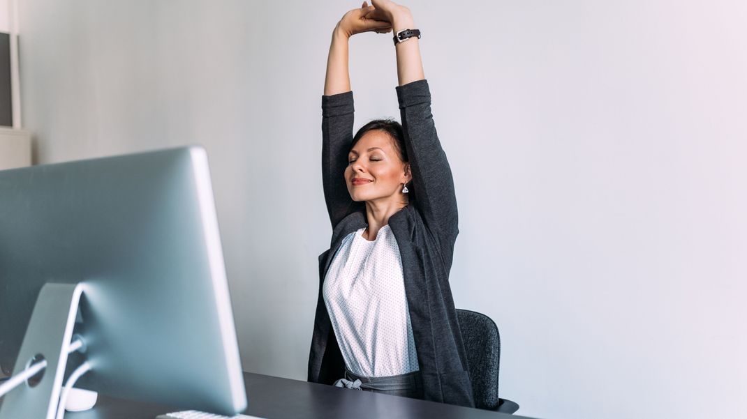 Regelmäßiges Dehnen des Rückens während der Arbeit am Schreibtisch kann helfen, Verspannungen zu lösen, die Flexibilität zu erhalten und die Konzentration zu steigern.