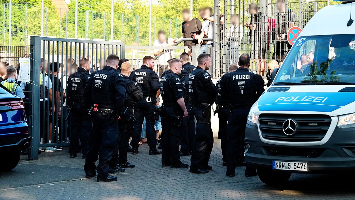 Einsatzkräfte der Polizei stehen vor der Bezirkssportanlage Bäuminghausstraße. 