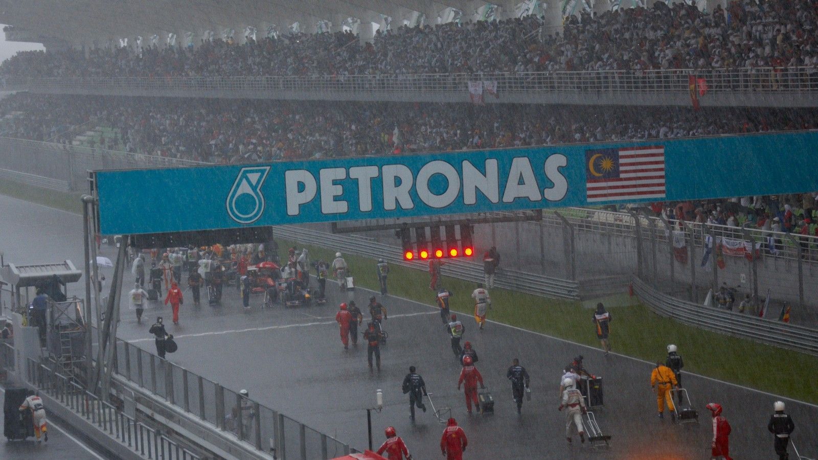 
                <strong>Malaysia-GP 2009</strong><br>
                In Sepang startete das Rennen seinerzeit auf trockener Strecke, nach 23 Runden jedoch begann es zu regnen – und das immer heftiger. Erst wurde das Safety Car losgeschickt, weil aber ein Pilot nach dem anderen abflog, wurde das Rennen nach 31 Runden mit der roten Flagge unterbrochen. Die Boliden wurden daraufhin auf der Start- und Zielgeraden postiert, in der Hoffnung einer Fortsetzung. Vergeblich wurde versucht, die Autos vor dem Monsun zu schützen. Um kurz vor 19 Uhr Ortszeit verkündete die Rennleitung, dass der Grand Prix wegen der anstehenden Dunkelheit nicht mehr gestartet wird. Nach insgesamt 55:30 Minuten Renndauer wurde Brawn-Pilot Jenson Button zum Sieger erklärt.
              