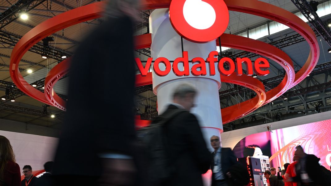 Barcelona: Menschen gehen auf der Mobilfunk-Messe Mobile World Congress (MWC) am&nbsp;Stand des Telekommunikationskonzerns Vodafone vorbei.