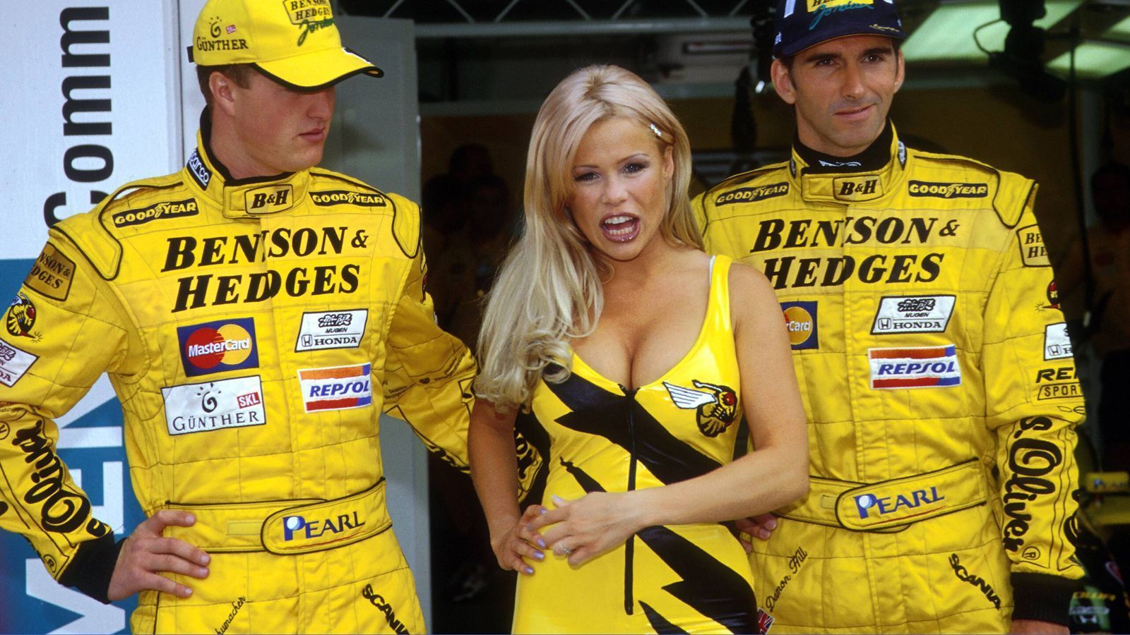 
                <strong>GP Australien 1998</strong><br>
                Ralf Schumacher bestimmt nicht. Der kann die Augen von diesem Grid Girl kaum lassen. Ob Teamkollege Damon Hill wohl deshalb so verschmitzt lacht?
              