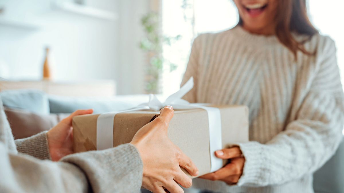 Excited asian woman getting surprise gift from her girlfriend at home. Gives a gift, birthday gift, New year day celebration and congratulation