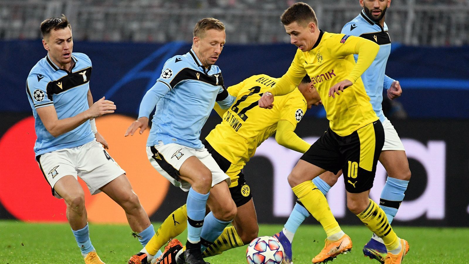 
                <strong>Thorgan Hazard</strong><br>
                Ähnlich wie Reyna, so braucht auch der Belgier Hazard etwas länger, um in diese Partie gegen Lazio reinzufinden. Nach einem deutlich zu hoch angesetzten Distanzschuss hat er aber dann beim 1:0 seine Beine im Spiel. Seinen Pass in die Tiefe auf Guerreiro verwandelt der Dortmunder. ran-Note: 2
              