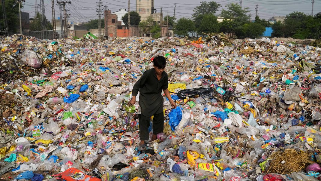 Ein Müllsammler in Pakistan sammelt wiederverwertbare Gegenstände, darunter Plastik, auf einer Mülldeponie. In Genf finden derzeit Verhandlungen über eine UN-Plastik-Konvention statt.