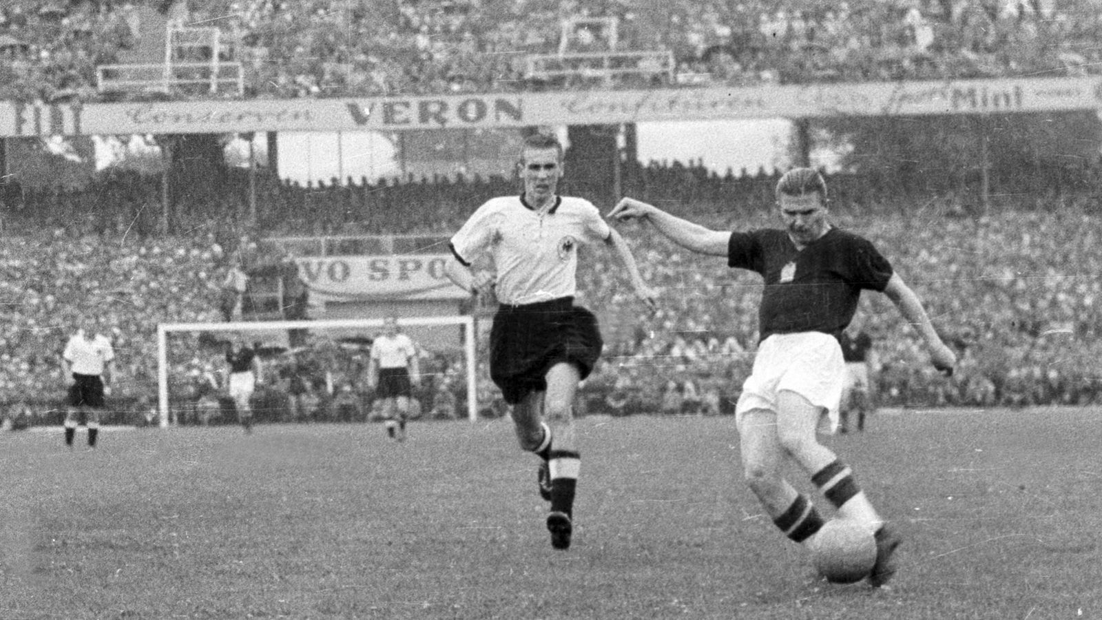 
                <strong>Ungarn war im WM-Finale 1954 haushoher Favorit</strong><br>
                Die Ungarn galten damals als beste Mannschaft der Welt, auch angesichts des 3:8 im Gruppenspiel wenige Tage zuvor, war Deutschland krasser Außenseiter, als sich die beiden Mannschaften im Finale der WM 1954 wiedertrafen. Und tatsächlich führte Ungarn schon nach acht Minuten mit 2:0, das Spiel schien den erwarteten Verlauf zu nehmen. Hier zieht Ferenc Puskas (r.) vor Horst Eckel ab.
              