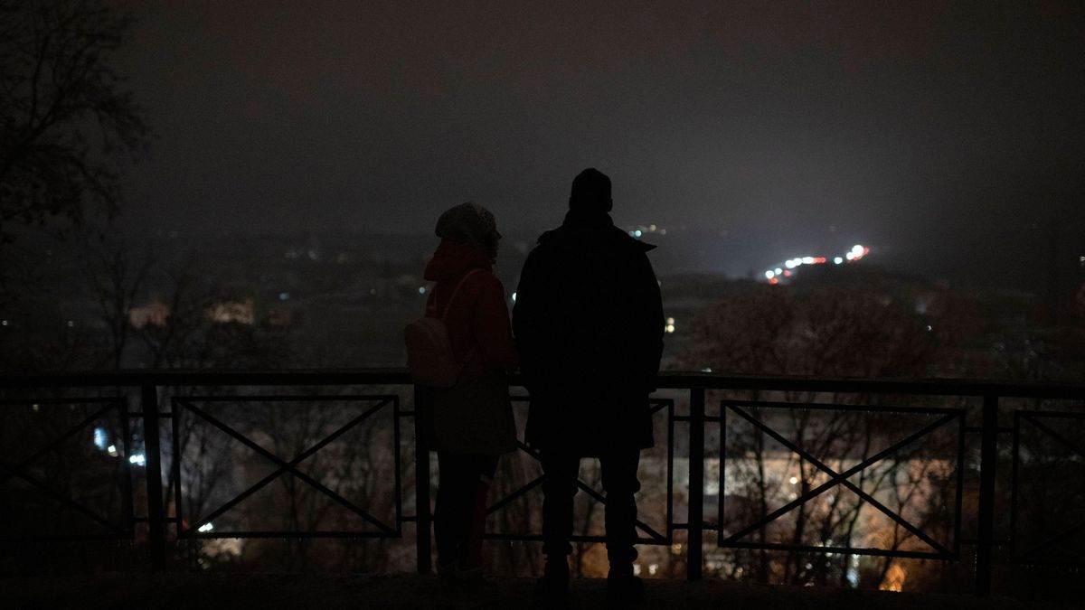 Menschen stehen während eines Stromausfalls nach einem russischen Raketenangriff an einem Aussichtspunkt. 