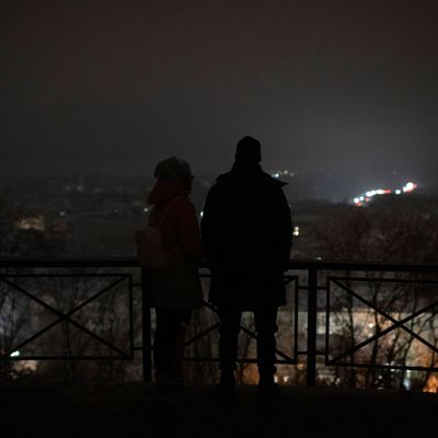 Menschen stehen während eines Stromausfalls nach einem russischen Raketenangriff an einem Aussichtspunkt. 