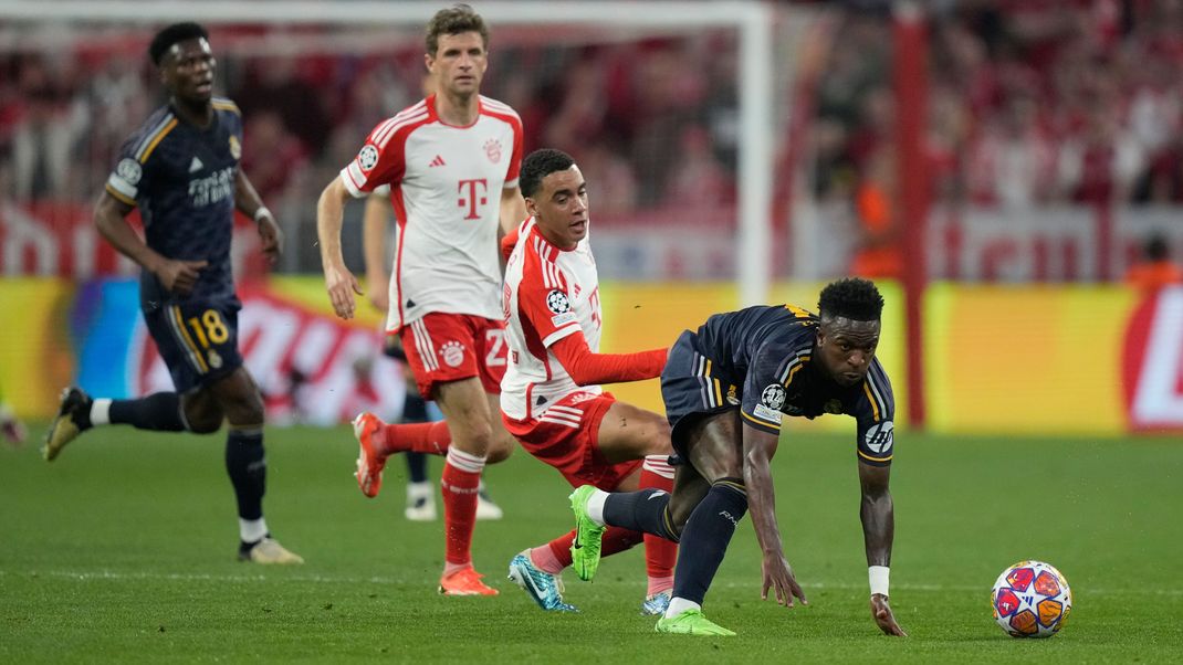 Vinicius Junior (Real Madrid), rechts, wird von Jamal Musiala (FC Bayern) während des Champions-League-Halbfinal-Hinspiels in der Allianz Arena in München am 30. April 2024 angegriffen. 