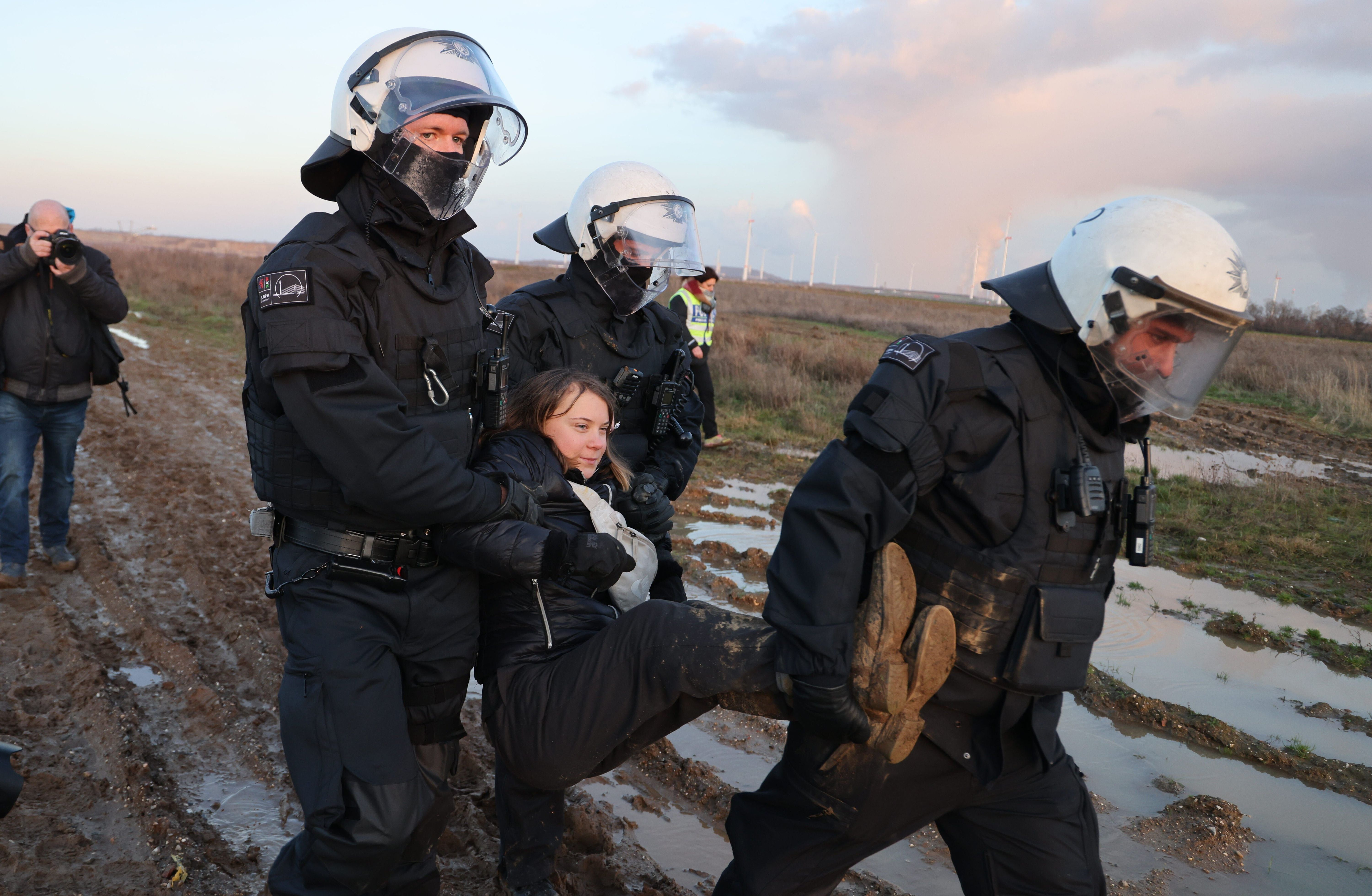 Polizisten tragen die schwedische Klimaaktivistin im Januar 2023 aus einer Gruppe von Demonstrant:innen und Aktivist:innen heraus und vom Rand des Braunkohlentagebaus Garzweiler II weg.