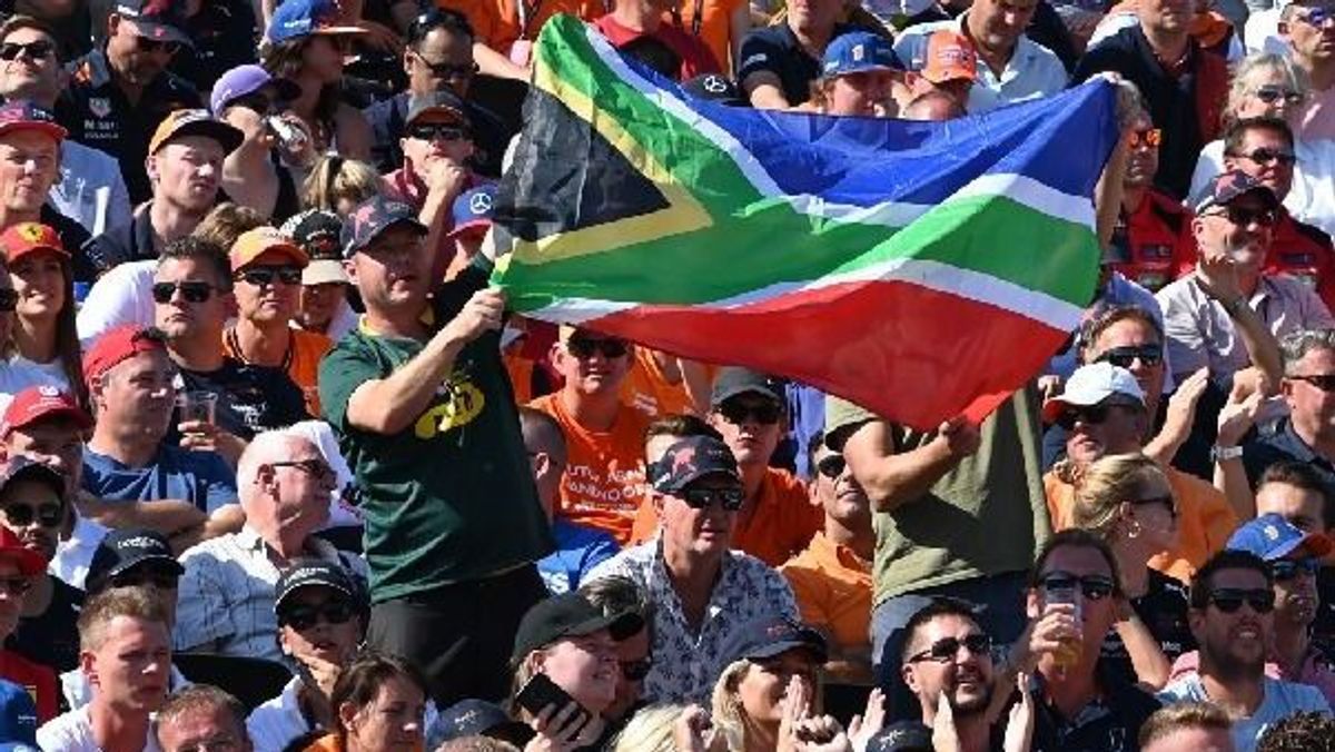 Ein Zuschauer hält die Nationalflagge von Südafrika hoch