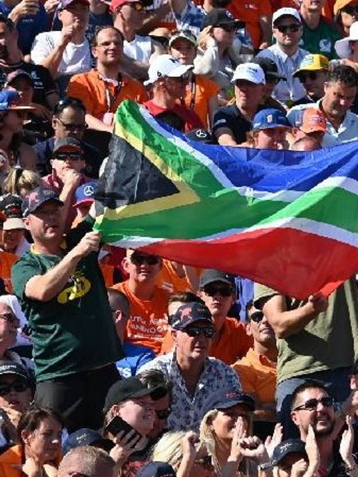 Ein Zuschauer hält die Nationalflagge von Südafrika hoch