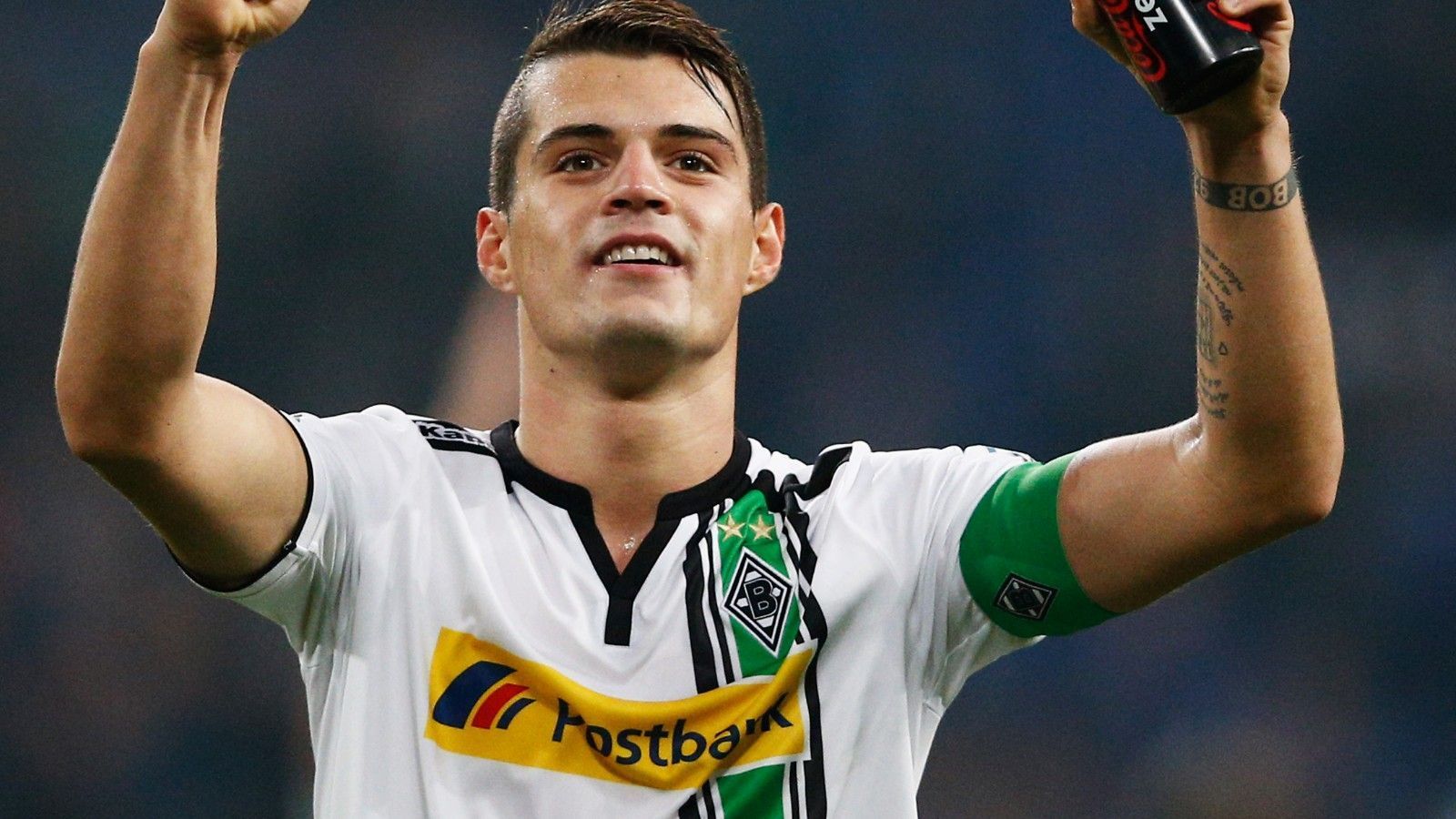 
                <strong>Defensives Mittelfeld: Granit Xhaka</strong><br>
                Der Schweizer kam 2012 vom FC Basel an den Niederrhein und konnte sich nach einer eher durchwachsenen Anfangszeit immer mehr in die Herzen der Gladbach-Fans spielen. Xhaka entwickelte sich schnell zu einem unnachahmlichen Abräumer und gleichzeitig auch Antreiber im defensiven Mittelfeld der Fohlen, räumte ab und dirigierte seine Mitspieler. 2015 wurde der Schweizer sogar Kapitän der Borussia, war aus diesem Team eigentlich auch nicht mehr wegzudenken. Doch ein Jahr später wechselte er für rund 45 Millionen Euro in die englische Premier League zum FC Arsenal. Bis heute die höchste Summe, die Gladbach für einen Spieler je kassiert hat.
              