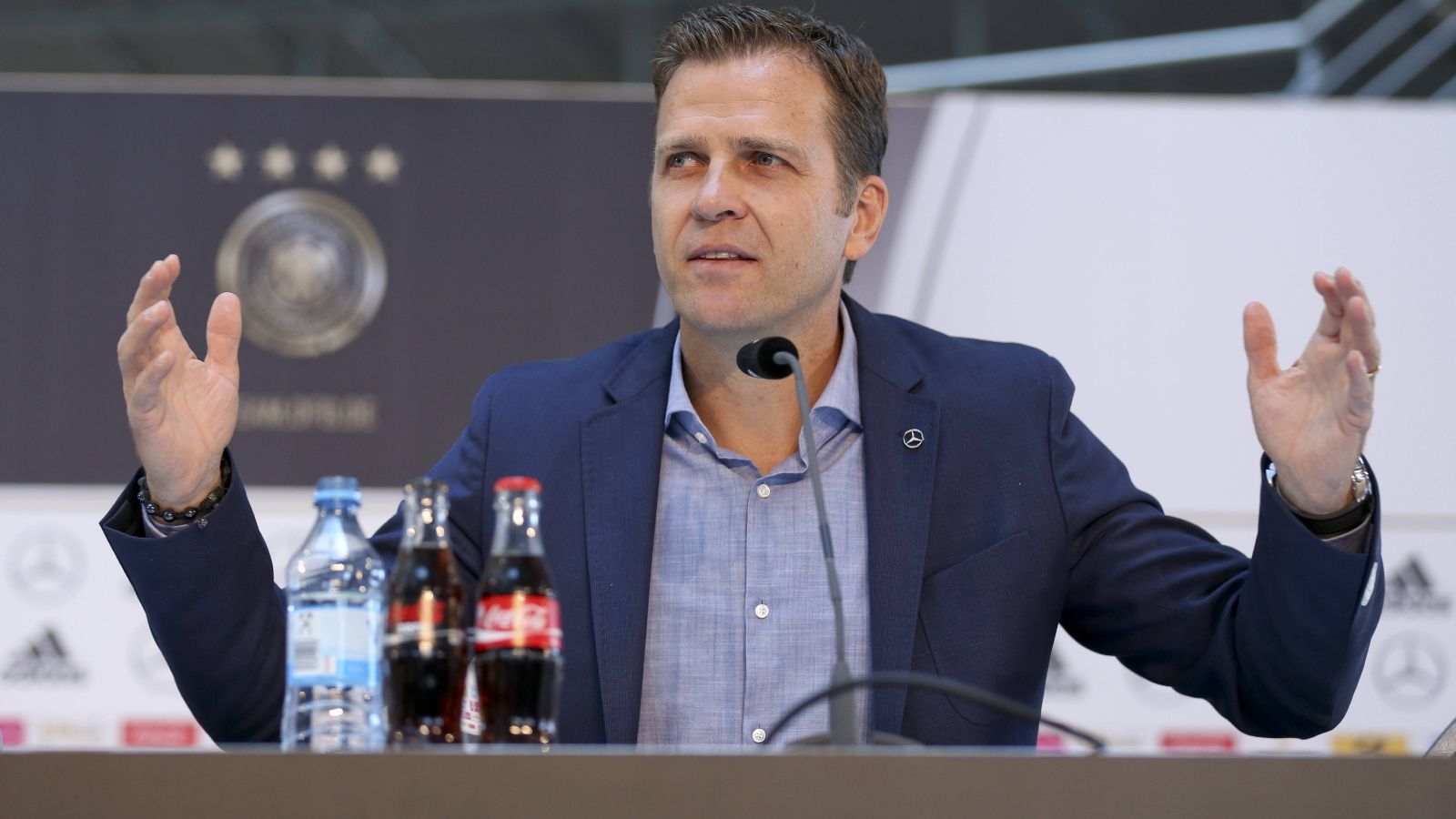 
                <strong>2015: "Die Mannschaft" als Marke wird eingeführt</strong><br>
                Am Ende des Jahres 2014 erschien ein Film über den Titelgewinn der DFB-Elf namens "Die Mannschaft". Dieses Branding nahm Oliver Bierhoff ein Jahr später auf und etablierte die gleichnamige Marke für die Nationalmannschaft. Hintergrund war, dass Deutschland keinen richtigen Spitznamen hat - anders als Italien, Argentinien, Brasilien oder Mexiko. Im Ausland sprach man häufiger von "Die Mannschaft" - in Deutschland aber nicht. Dass Bierhoff den als Marketing-Begriff verstandenen Namen trotzdem durchsetzte, brachte ihm viel Kritik ein.
              